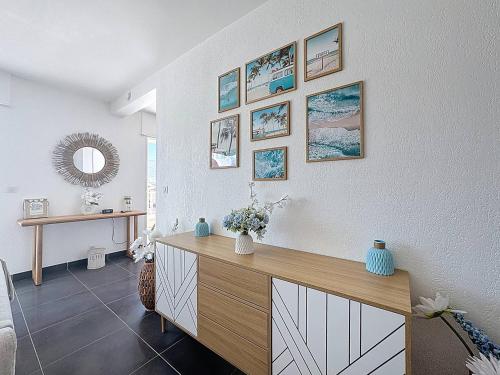 - un salon avec une commode en bois et des photos sur le mur dans l'établissement T3 d’Exception avec Vue Panoramique sur la Baie de Calvi, à Calvi
