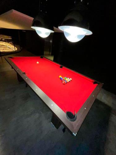 a red pool table with balls on top of it at Excelente! Vista al mar con cochera y amenities gimnasio, play room y pileta no climatizada in Mar del Plata