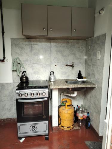 Una cocina con estufa y una encimera con tetera. en Lo de Su, en Salta
