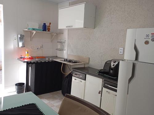 a small kitchen with a stove and a refrigerator at Kit pequeno espaco popular in Riacho Fundo
