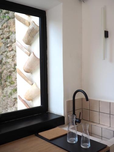 deux vases en verre posés sur un comptoir à côté d'un miroir dans l'établissement PROVENCE VAR Bel appartement 2 pièces indépendant dans un Magnifique Domaine, à Bras