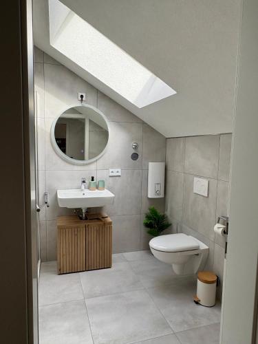 a bathroom with a sink and a toilet and a mirror at ALLGÄUHERZ - Ferienwohnung zentral in Nesselwang - inklusive KÖNIGSKARTE in Nesselwang