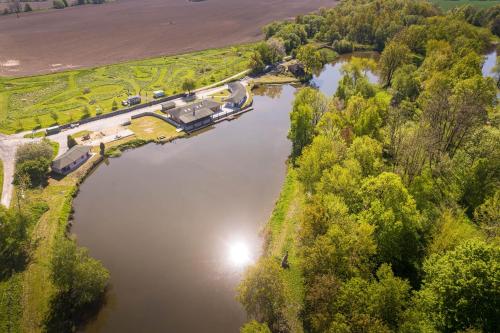 an aerial view of a river with trees and a house at Marine Závlahy in Hrdějovice