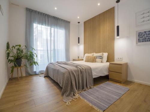 Un dormitorio con una cama y una ventana grande. en Seafront Apartment in Calella with Beach Access, en Calella