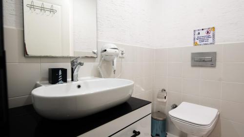 a bathroom with a white sink and a toilet at Limonata Bozcaada ex Vina Garden in Bozcaada