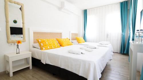 a bedroom with two beds with yellow pillows at Limonata Bozcaada ex Vina Garden in Bozcaada