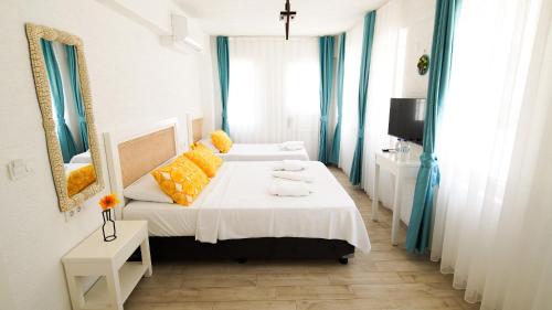 a hotel room with two beds and a mirror at Limonata Bozcaada ex Vina Garden in Bozcaada