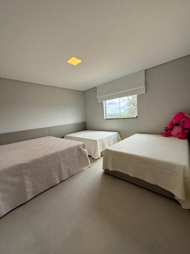 a bedroom with two beds and a window at Sítio em Jequitibá Vista Incrível Próximo a Sete Lagoas in Jequitibá