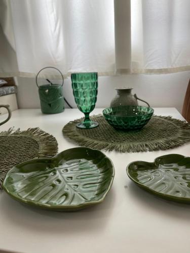 a group of green plates and vases on a table at Apartament Drasa in Gjirokastër