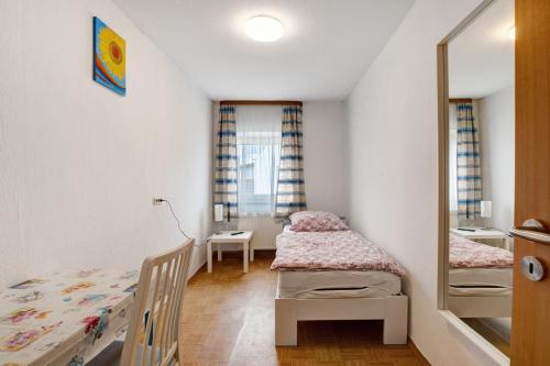 a small bedroom with two beds and a mirror at Haus Steinheim in Dillingen an der Donau
