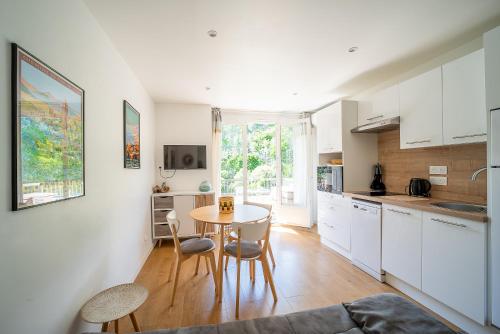 une cuisine avec une table et des chaises dans une pièce dans l'établissement Le Cocon Thermal - Climatisé vue montagne, à Amélie-les-Bains-Palalda