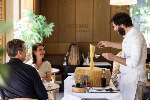 a man feeding a man food in a restaurant at Pillows Grand Boutique Hotel Maurits at the Park - Small Luxury Hotels in Amsterdam