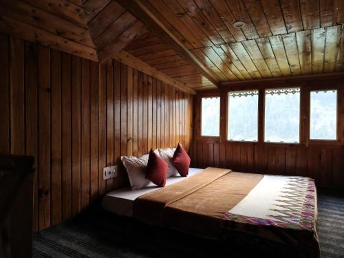 JibhiにあるMountain retreatの木製の部屋にベッド1台が備わるベッドルーム1室があります。