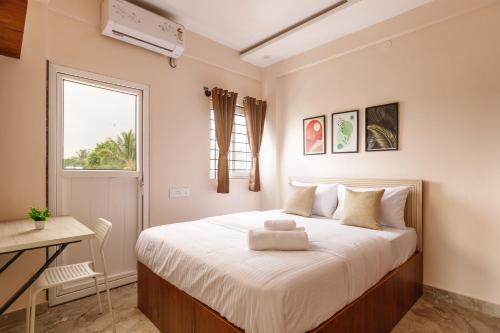 a bedroom with a bed and a desk and a window at OBS 1BHK with Balcony Koramangala in Bengaluru