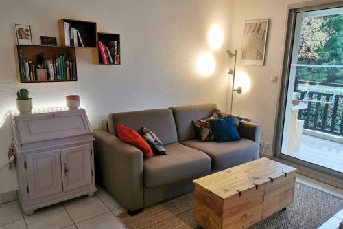 een woonkamer met een bank en een tafel bij T2 cosy - vue sur le golf - proche plage in Pornic