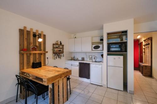 een keuken met een houten tafel en witte apparaten bij T2 cosy - vue sur le golf - proche plage in Pornic