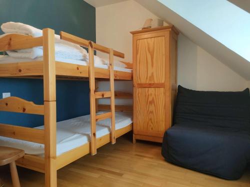 Cette chambre dispose de lits superposés avec 2 lits superposés et une chaise. dans l'établissement Ref 030 Maison moderne magnifique vue mer pour six personnes, à Arzon