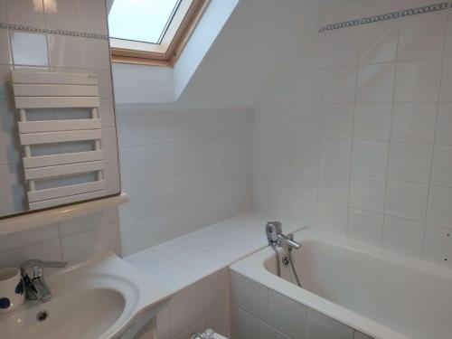 une salle de bain blanche avec un lavabo et une baignoire dans l'établissement Ref 030 Maison moderne magnifique vue mer pour six personnes, à Arzon