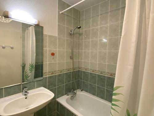 une salle de bain avec un lavabo, une baignoire et un miroir dans l'établissement Appartement T3 à 100m de l'océan, terrasse, animaux acceptés, bien aménagé pour vacances - FR-1-379-75, à Vieux-Boucau-les-Bains