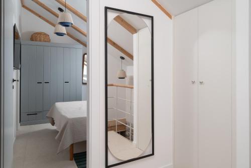 a mirror in a white room with a bedroom at Stone house Casa Lumina in Božava