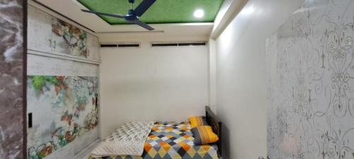 ハイデラバードにある2BHK AC Hitech City-Enjoy like your home Affordable Comfortableのベッドと天井扇風機のある寝室