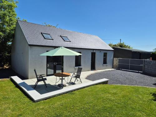 a patio with a table and a green umbrella at Farm View Lodge in Kilkenny