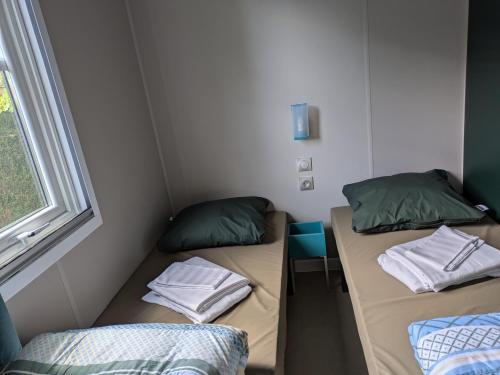 two beds in a room with a table and a window at Camping Houtum in Kasterlee