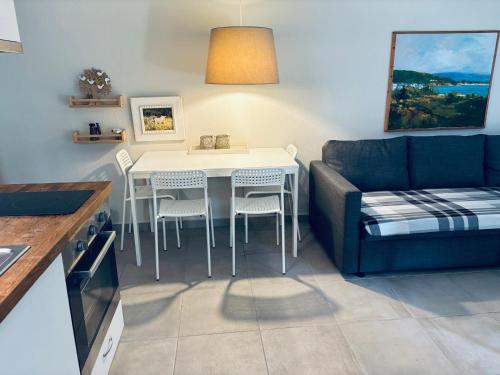 a living room with a couch and a table and chairs at Armonia Villas in Skala Rachoniou
