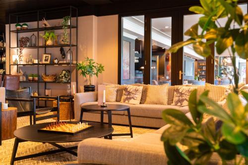 a living room with a couch and a table and chairs at Van der Valk Cuijk - Nijmegen in Nijmegen