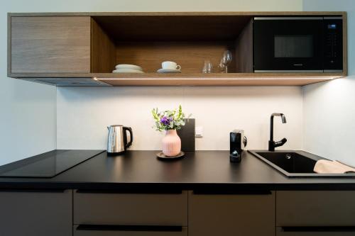 a kitchen counter with a sink and a microwave at Franz BY ZEITRAUM in Prague
