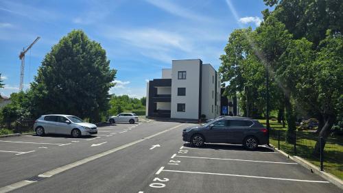 two cars parked in a parking lot next to a building at Apartman Jakov in Zagreb
