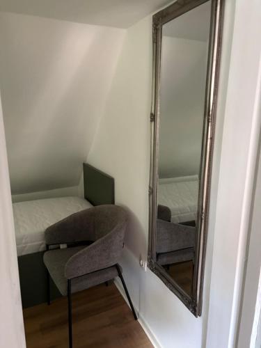 a mirror in a room with a bed and a chair at Captain's house in Karlovac