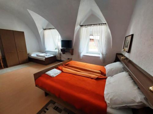 a bedroom with an orange bed in a room with arches at Hotel&Restaurant Gasthof zur Post Eisenerz in Eisenerz