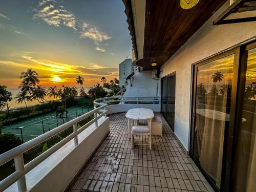 a balcony with a table and chairs and a sunset at Regency Tanjung Tuan - Idealhub in Port Dickson