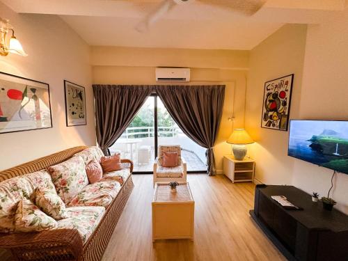 a living room with a couch and a tv at Regency Tanjung Tuan - Idealhub in Port Dickson
