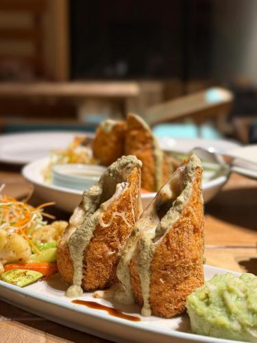 a plate of food with sandwiches and vegetables on a table at Rivage Resort Skardu in Shigar