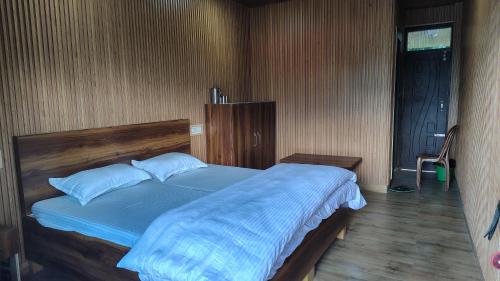 a bedroom with a large bed with blue sheets at Lucky home stay in Munsyari