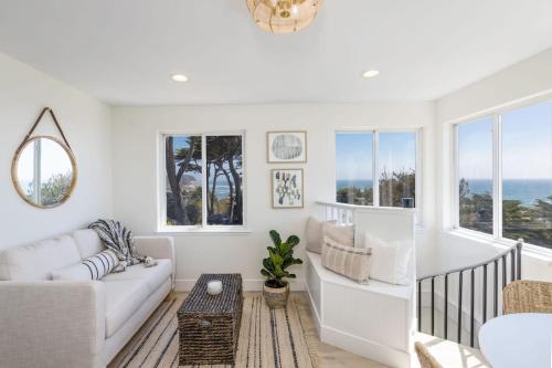 a living room with a couch and a table at Oceanfront Coastal Home with Breathtaking Views Hiking Beaches & More in Moss Beach