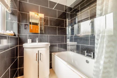 a bathroom with a white tub and a sink at Cornerways by Bloom Stays in Canterbury