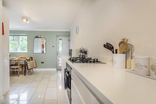 a kitchen with white counter tops and a dining room at Cornerways by Bloom Stays in Canterbury