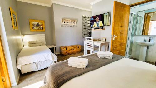 a small bedroom with two beds and a sink at Tiende Laan Bed & Breakfast and Self-Catering in Walvis Bay