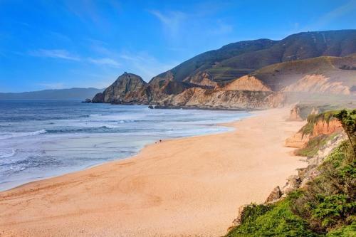 a beach with a view of the ocean and cliffs at Oceanfront Coastal Home with Breathtaking Views Hiking Beaches & More in Moss Beach