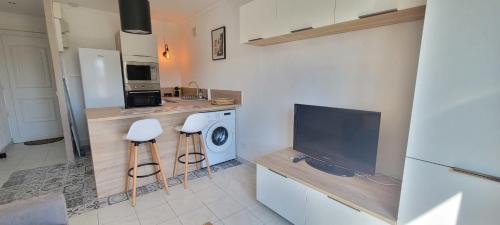 Il comprend une cuisine équipée d'un lave-linge et une télévision. dans l'établissement Cozy studio with balcony near beach, à Fréjus