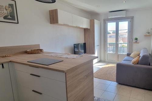 - une cuisine avec un comptoir et un canapé dans la chambre dans l'établissement Cozy studio with balcony near beach, à Fréjus