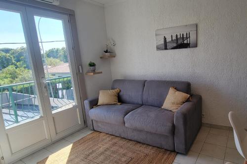 d'un salon avec un canapé et un balcon. dans l'établissement Cozy studio with balcony near beach, à Fréjus