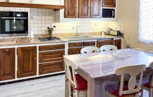 une cuisine avec des armoires en bois et une table avec des chaises dans l'établissement Lovely Home In Sablet, à Sablet