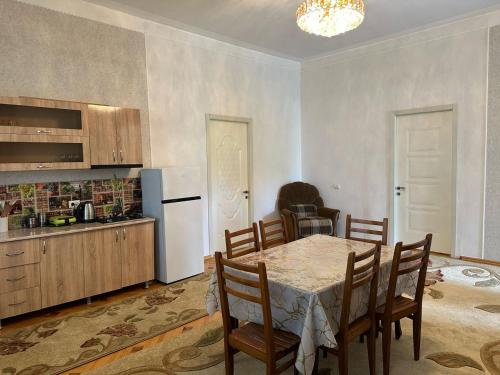 eine Küche und ein Esszimmer mit einem Tisch und einem Kühlschrank in der Unterkunft Lalitas sweet home in Kutaissi