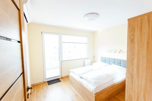 a bedroom with a bed and a window at VacationClub - Gierczak 15 Apartament 10 in Kołobrzeg