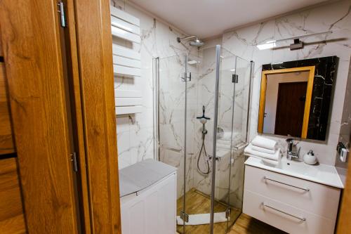 a bathroom with a shower and a sink at VacationClub - Gierczak 15 Apartament 10 in Kołobrzeg