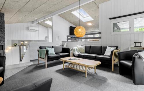 a living room with couches and a table at Awesome Home In Glesborg With Sauna in Fjellerup Strand